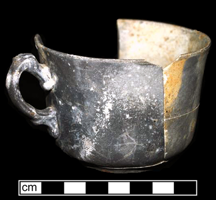 White granite handled cup.  Burned in 1915 fire that destroyed farmstead. Vessel height: 2.25”, Vessel rim diameter: 3.50”, Vessel V-132 - from 18MO609.